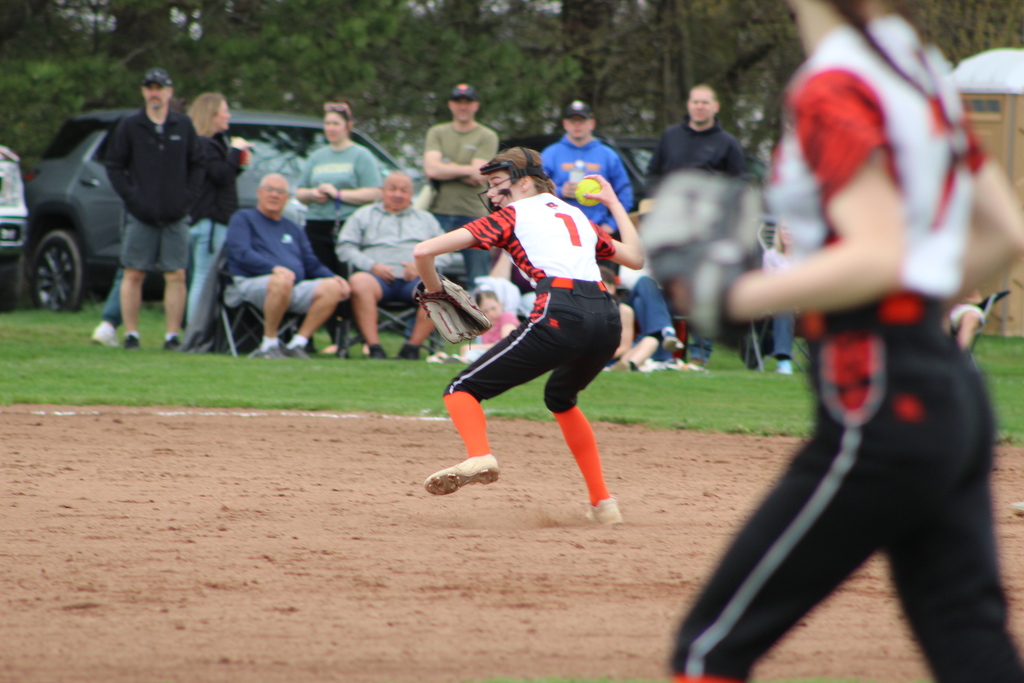 girl throwing ball in softball game