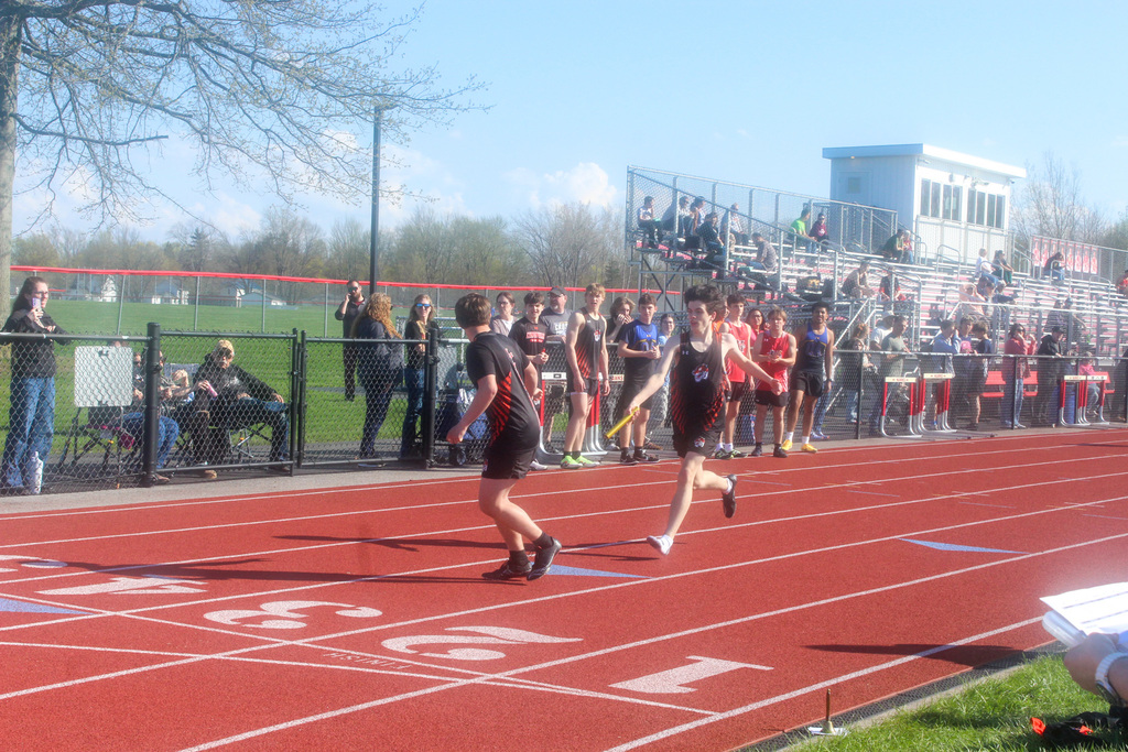 two boys handing off baton in relay race