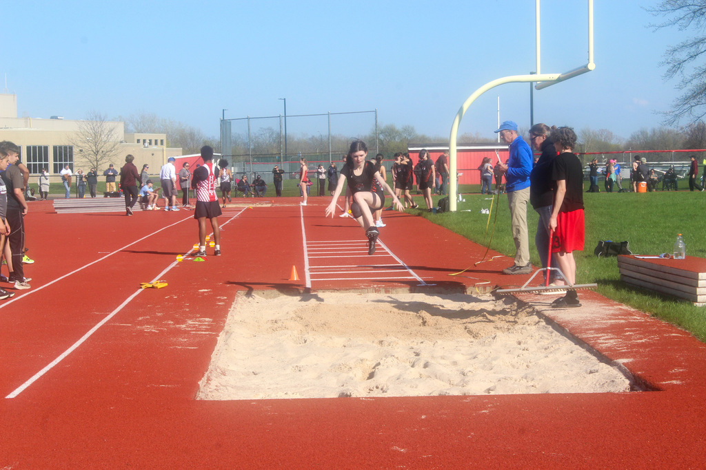 girl jumping into sand pit