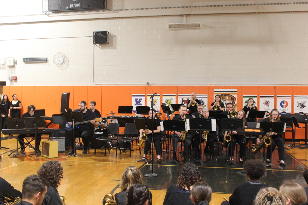 teachers and one student playing instruments in band