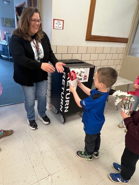 student giving flowers they made to teacher