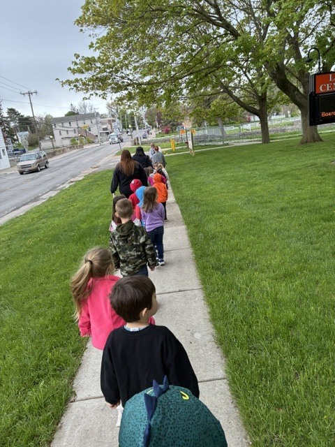 students walking down the sidewalk with adults