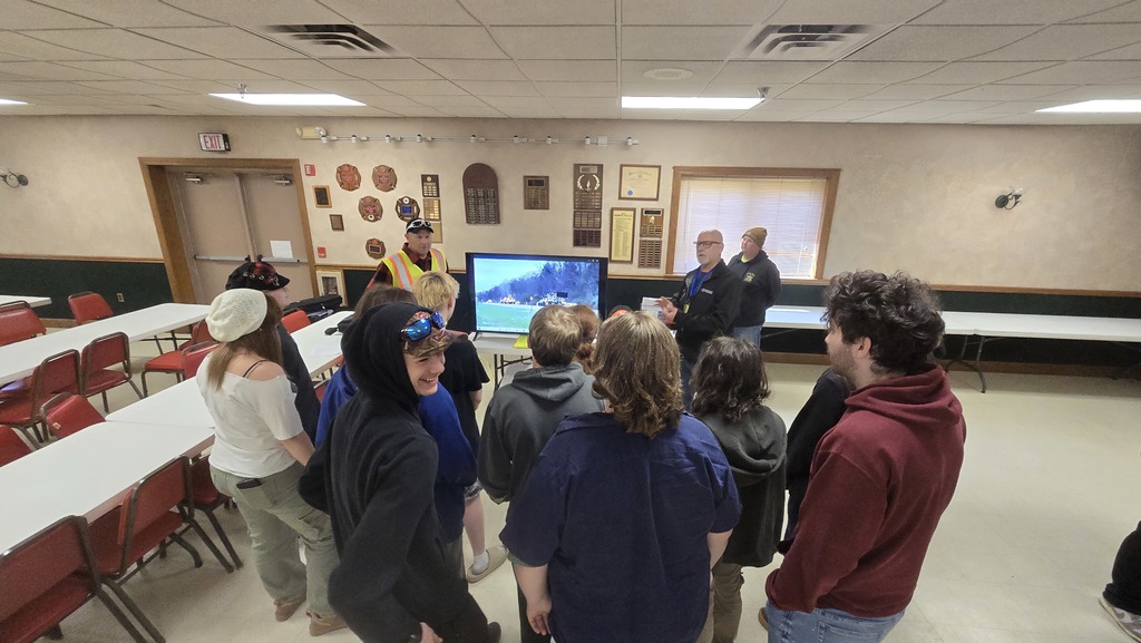 students listening to two adults speak
