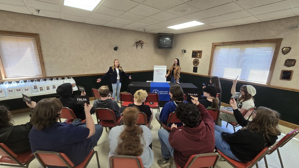 students listening to two adults speak