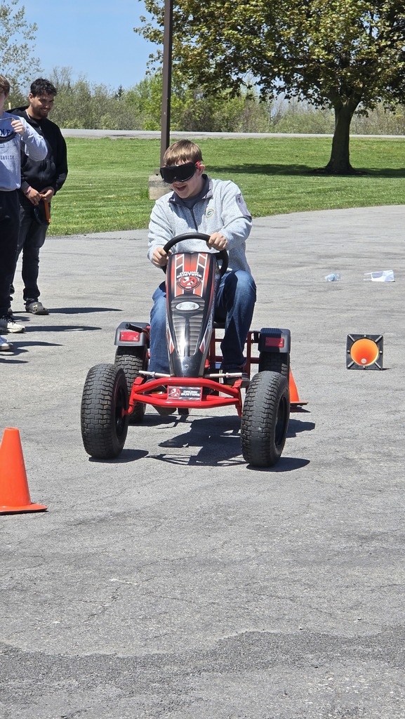 student driving a pedal bike with goggles on