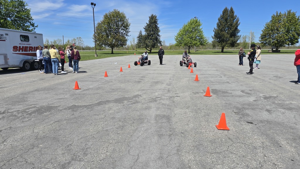 students driving pedal bikes on a course while wearing goggles