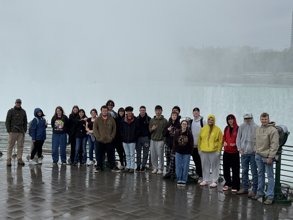 students and teachers standing in front of waterfalls