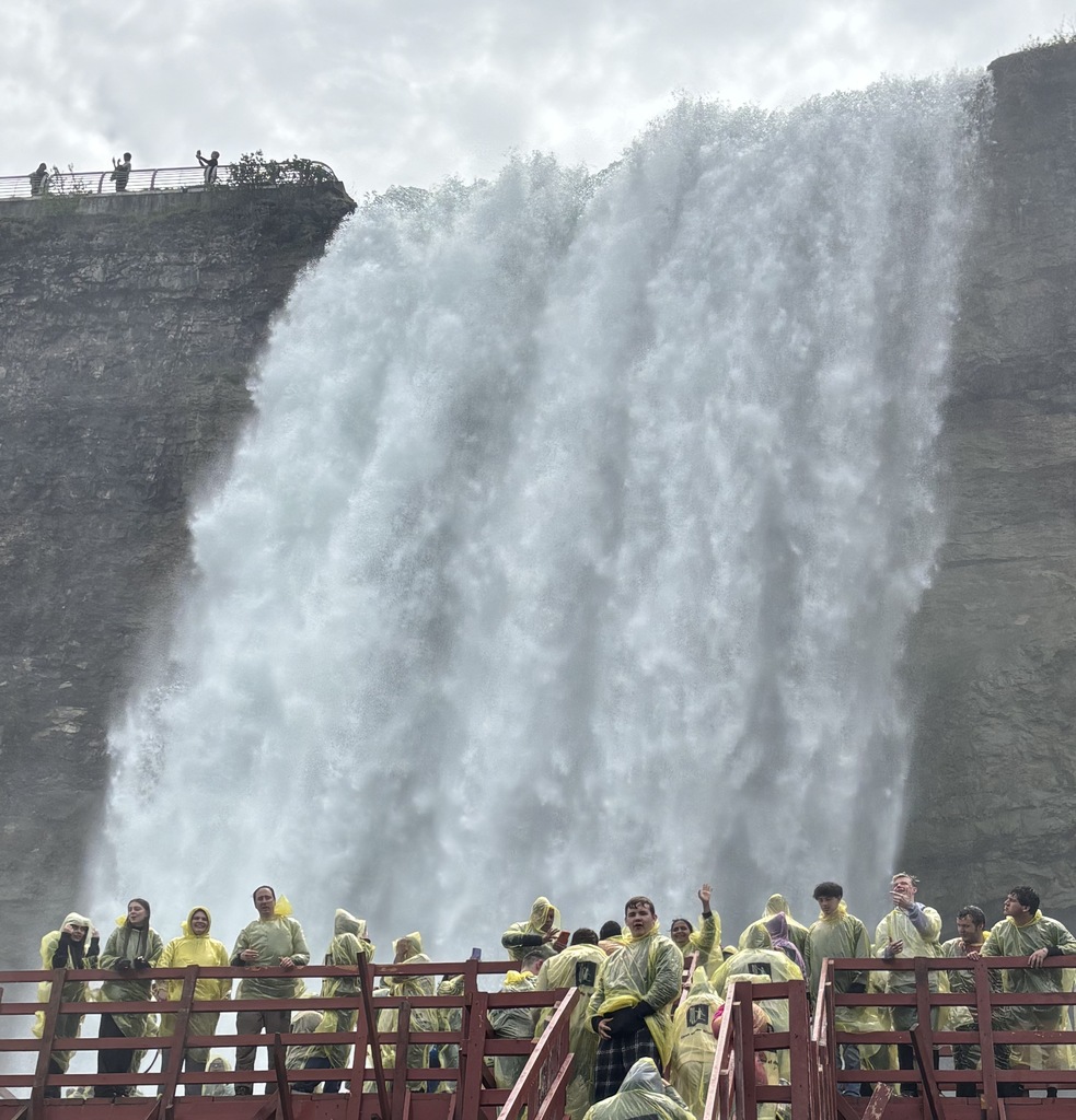 students standing at base of waterfalls
