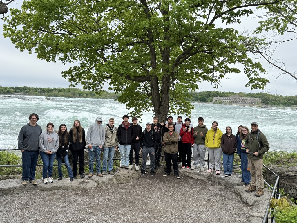 students and teachers standing near river