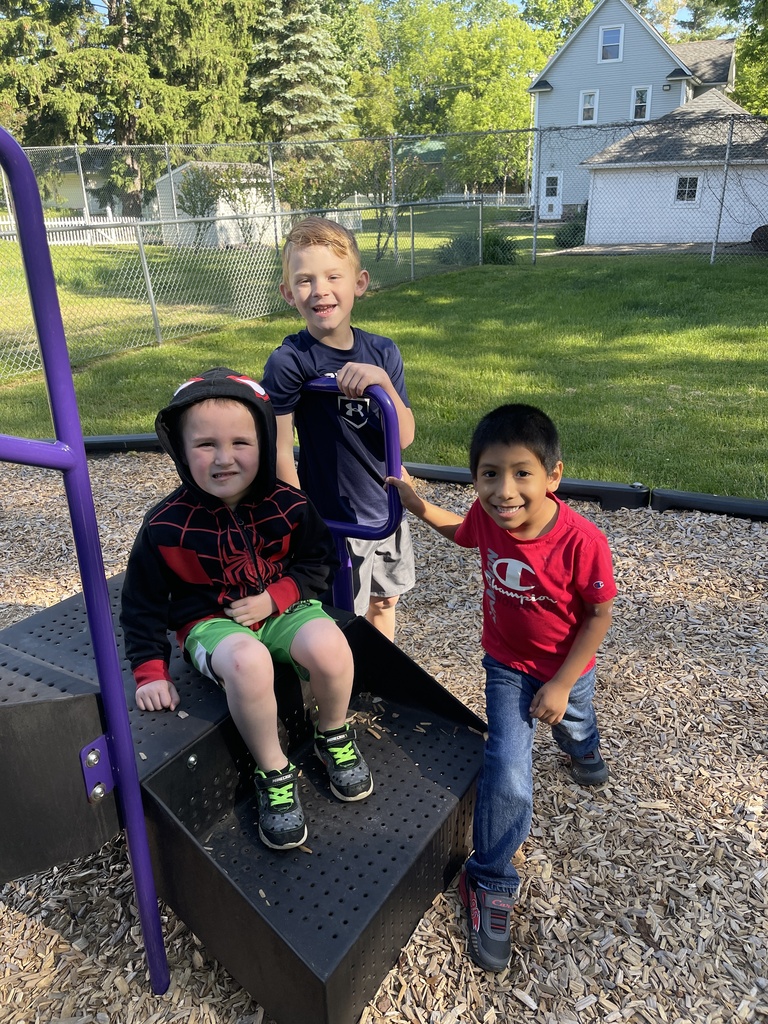 three students on playground equipment