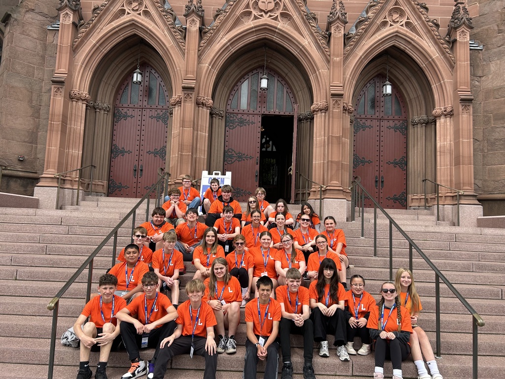 students sitting on steps in front of church