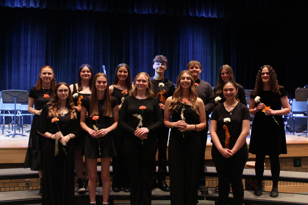 seniors holding flowers standing on risers