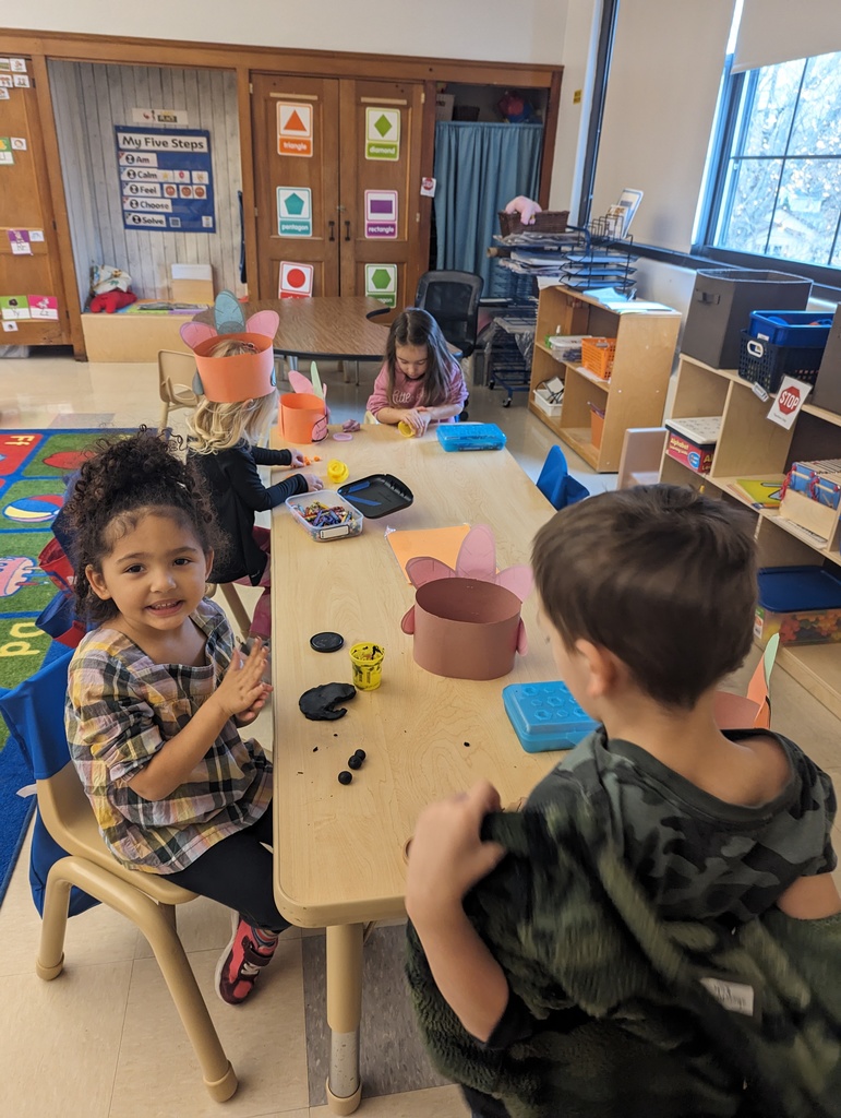 students sitting at table manipulating playdough