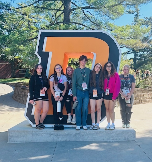 Students stand by Doane University sculpture