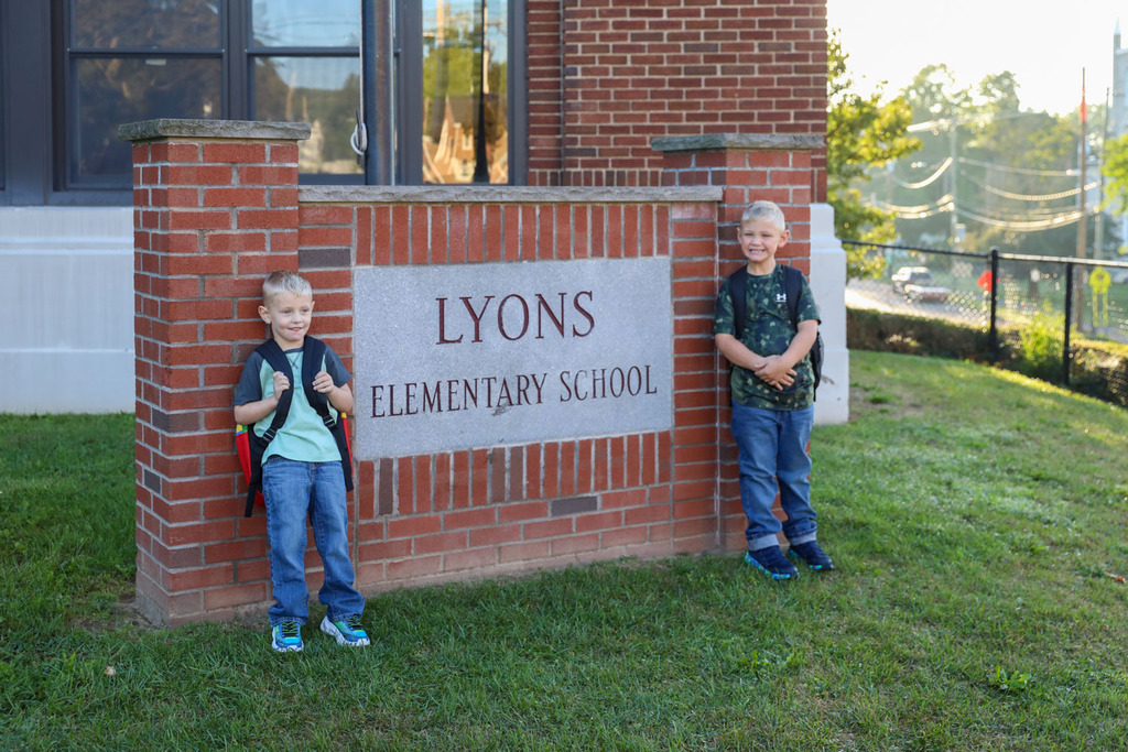 brothers in front of elementary sign