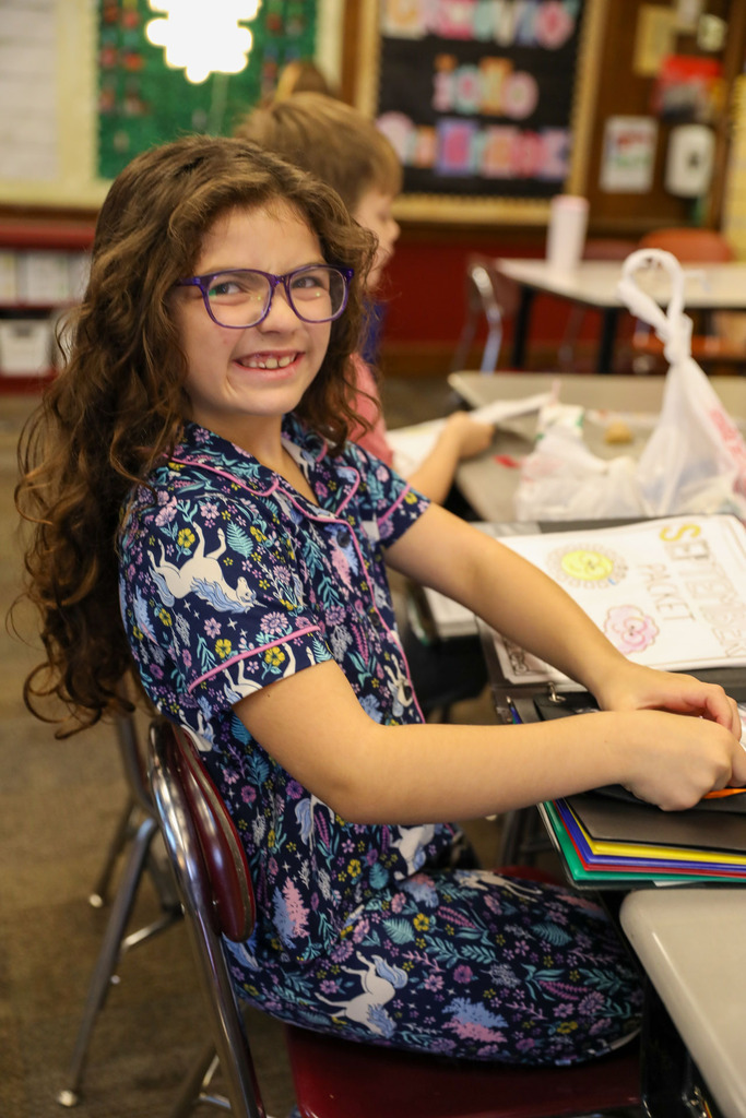 student at desk in jammies