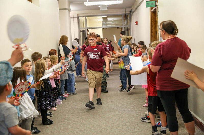 students holding cheering at the parade