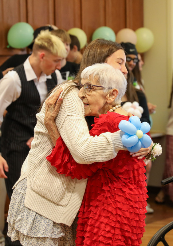 students and resident embrace