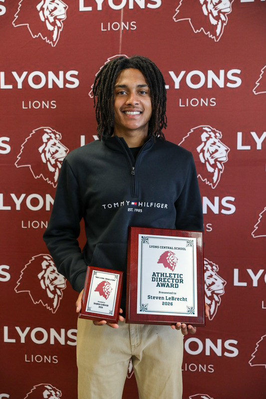student athlete posing with awards
