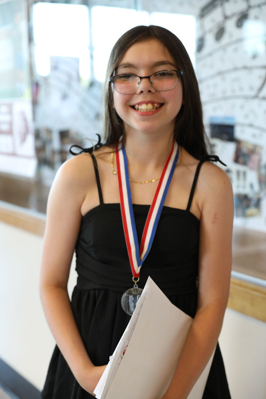 student with diploma smiling