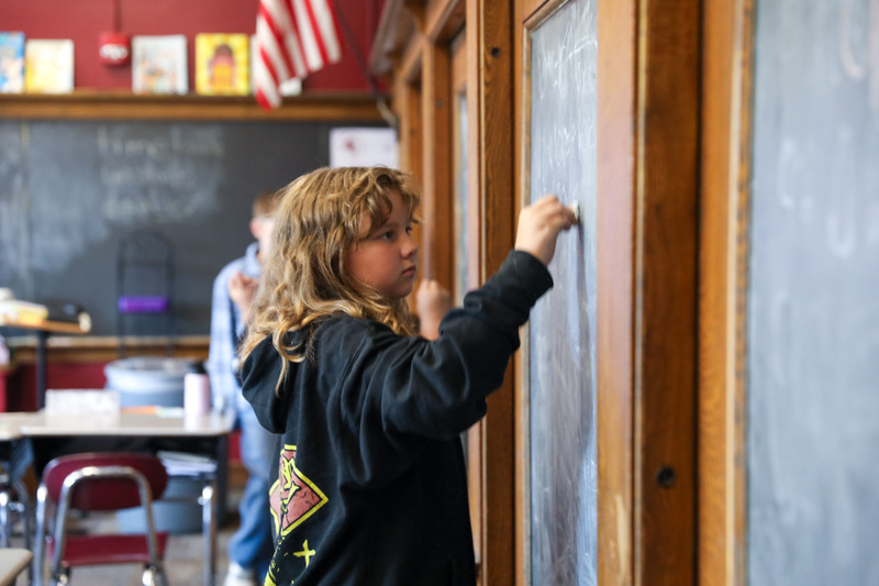 student at chalk board