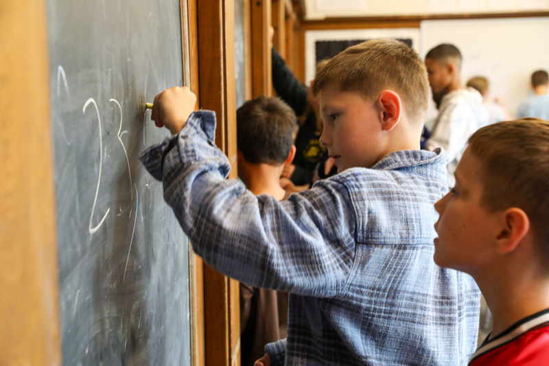 student writing with chalk
