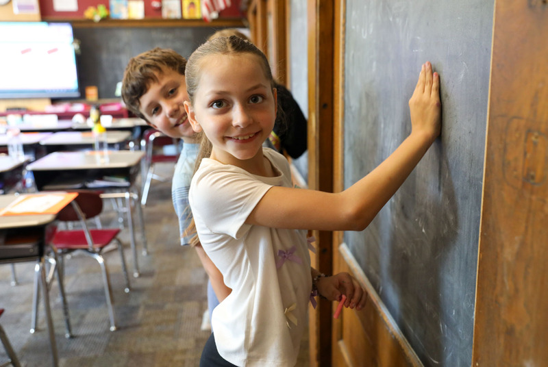 students working in pairs at chalk board