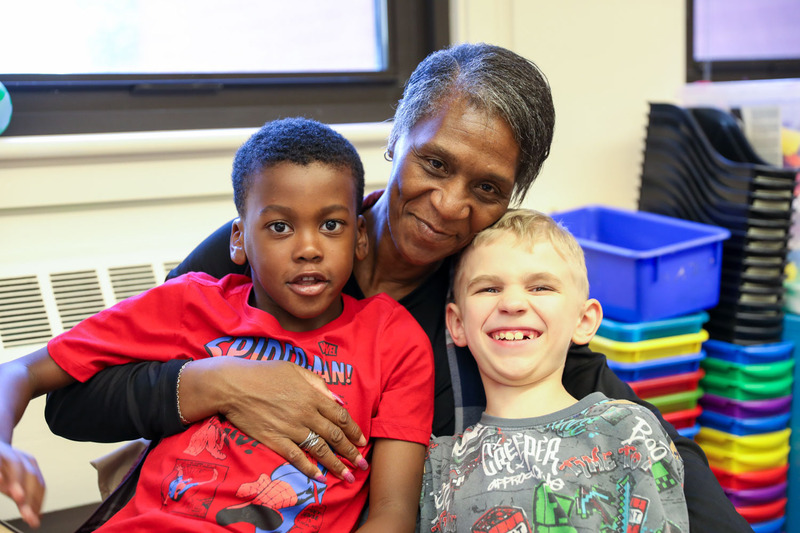 2 students posing with teacher