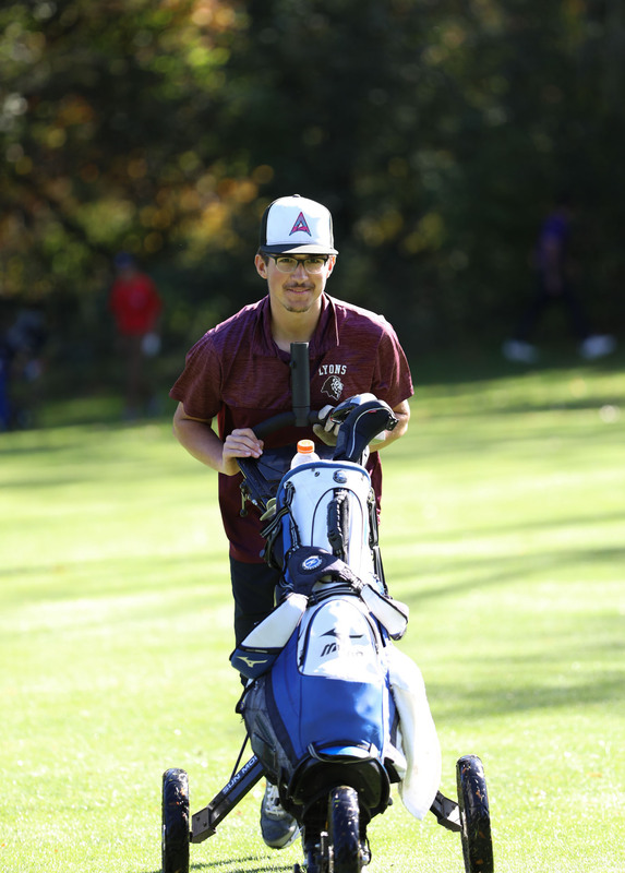 cole burnett wheeling his golf clubs on the green