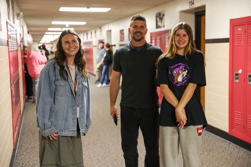 teacher, parent and student talking in hallway