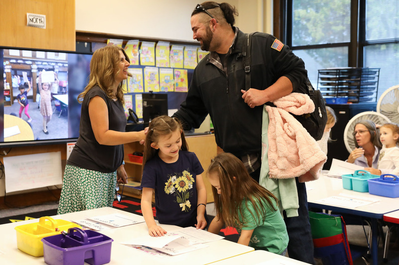 Parent shaking hands with teacher in classroom