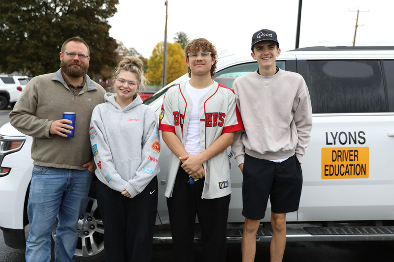 students standing in front of drivers ed car