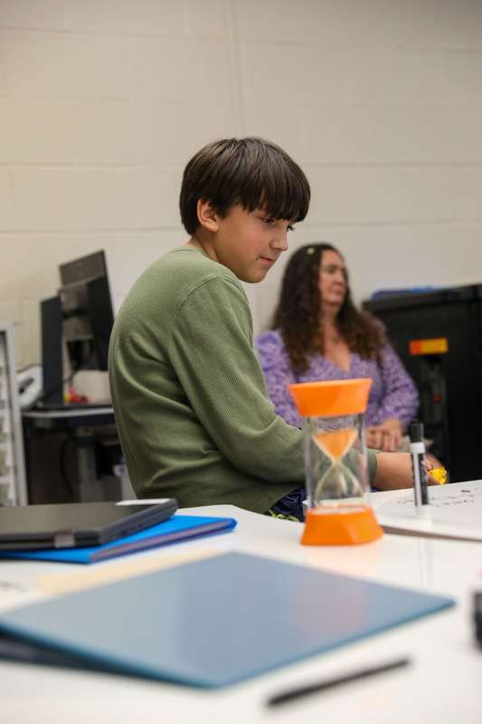 student in front of hour glass