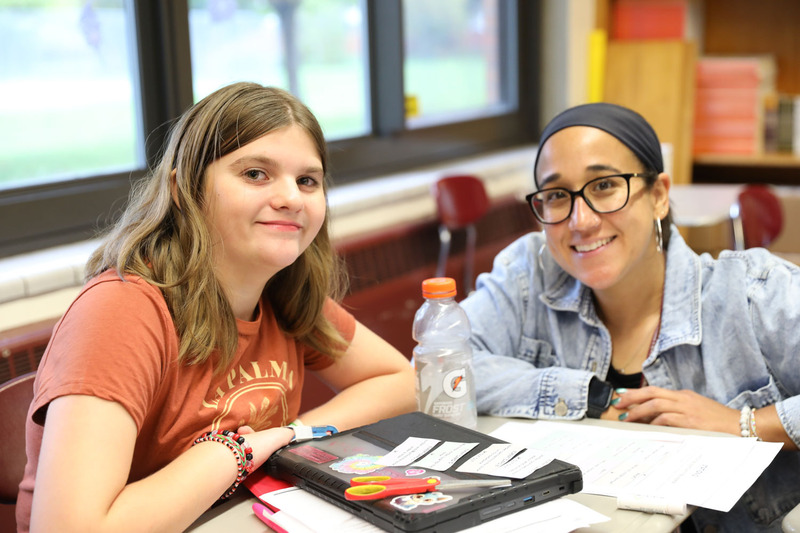 student and teacher posing at desk