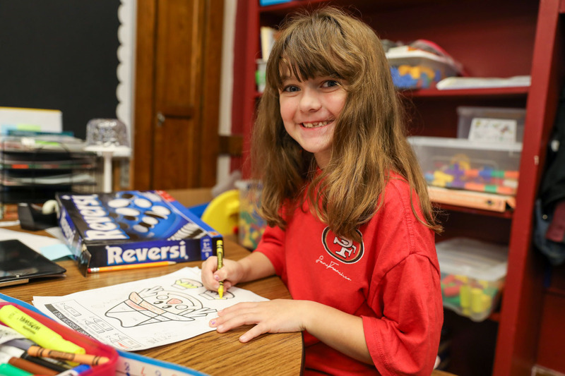 student working on math scarecrow at a table