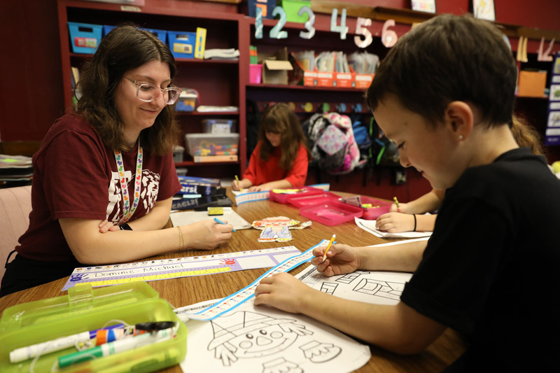 teacher helping students with math problems