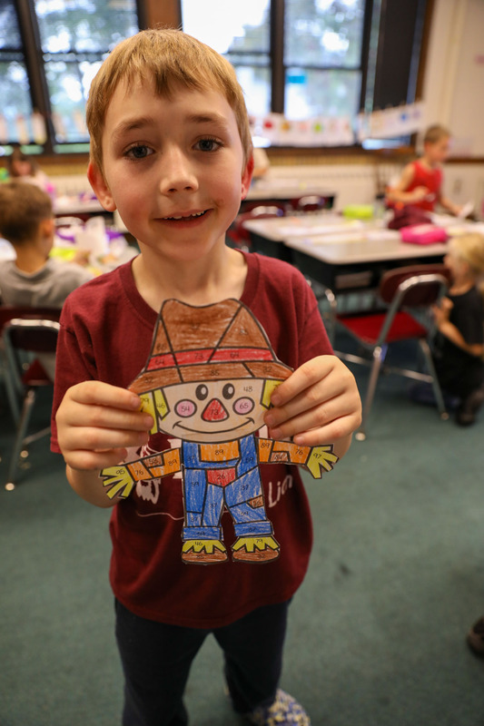 student holding scarecrow