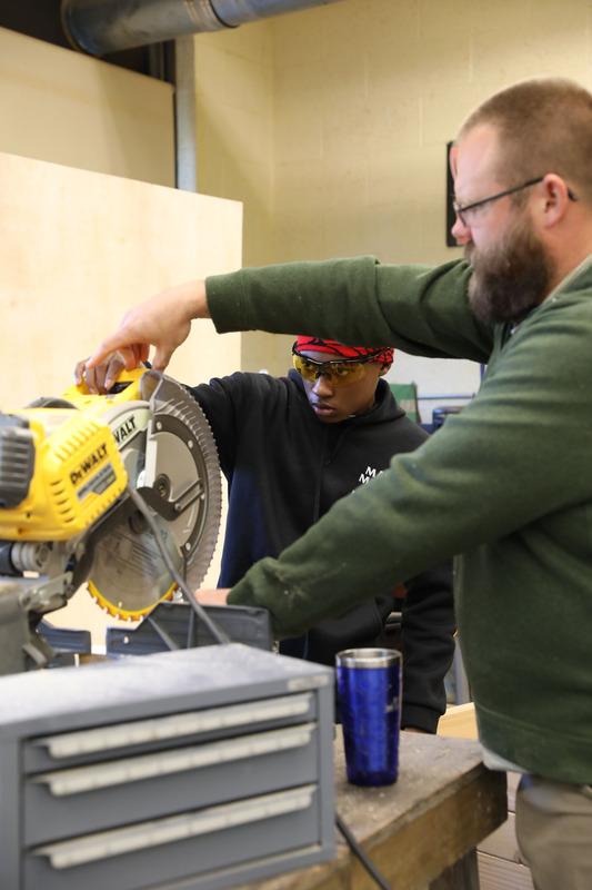 students in tech class with a saw