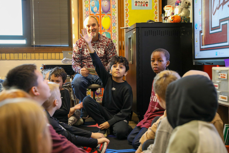 student raising hand at buddy day