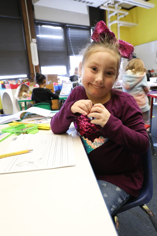 student with heart hands