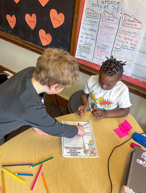 student working with younger student