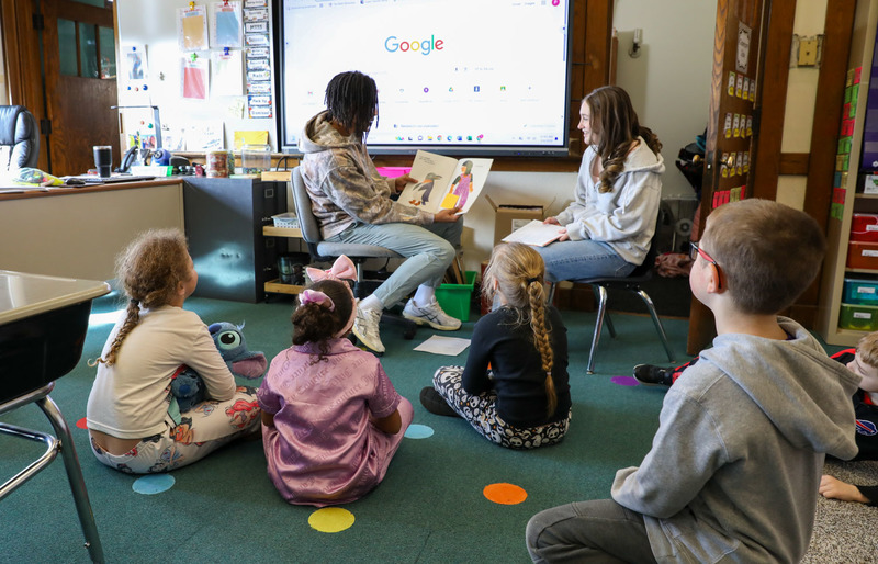 high schoolers reading to students