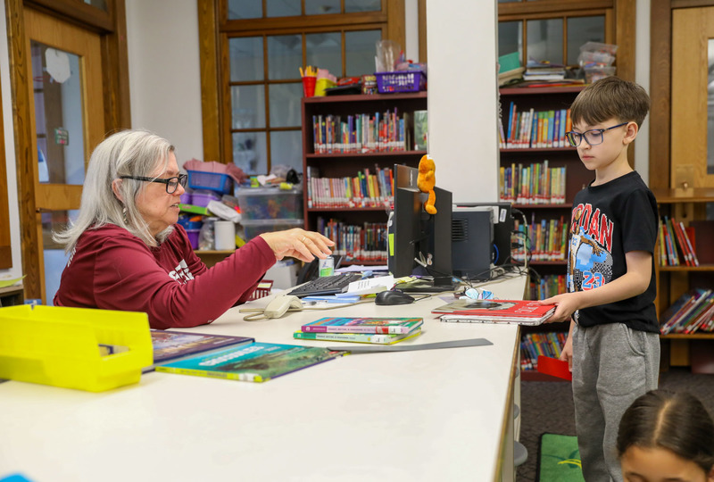 student checking out library book