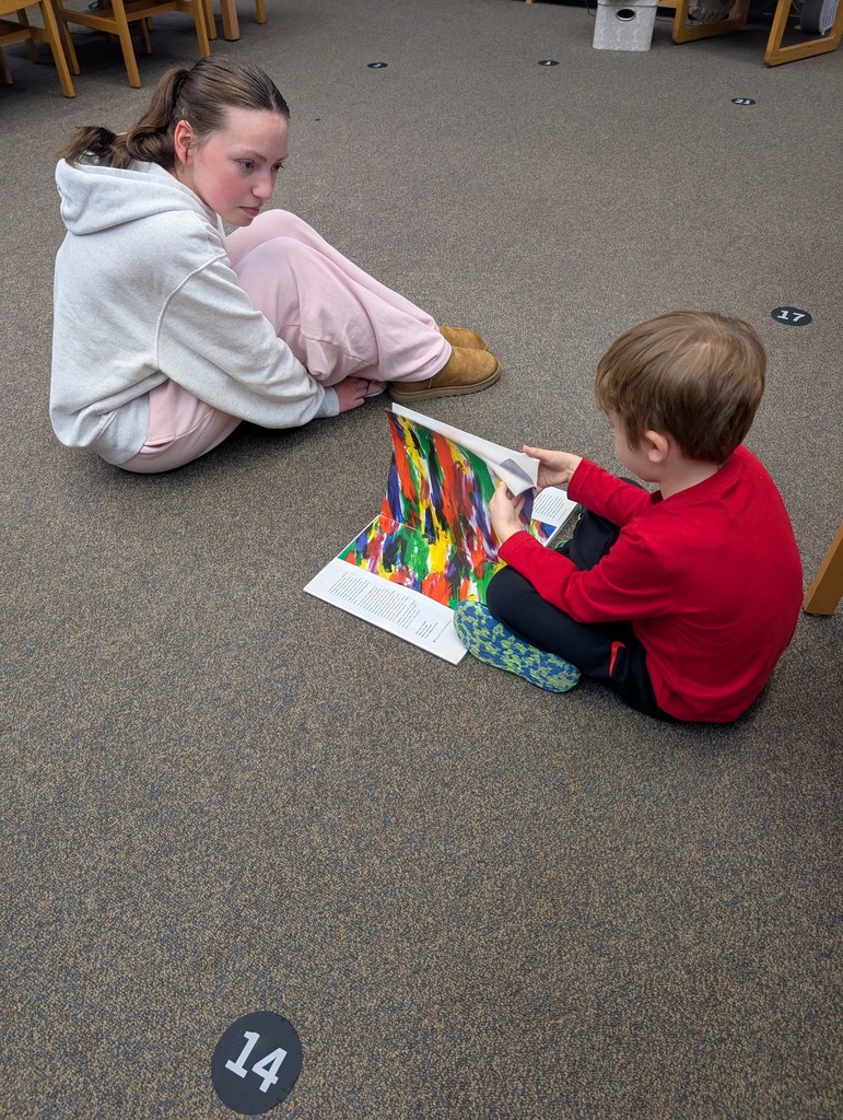 This picture is of a teacher reading to a student.
