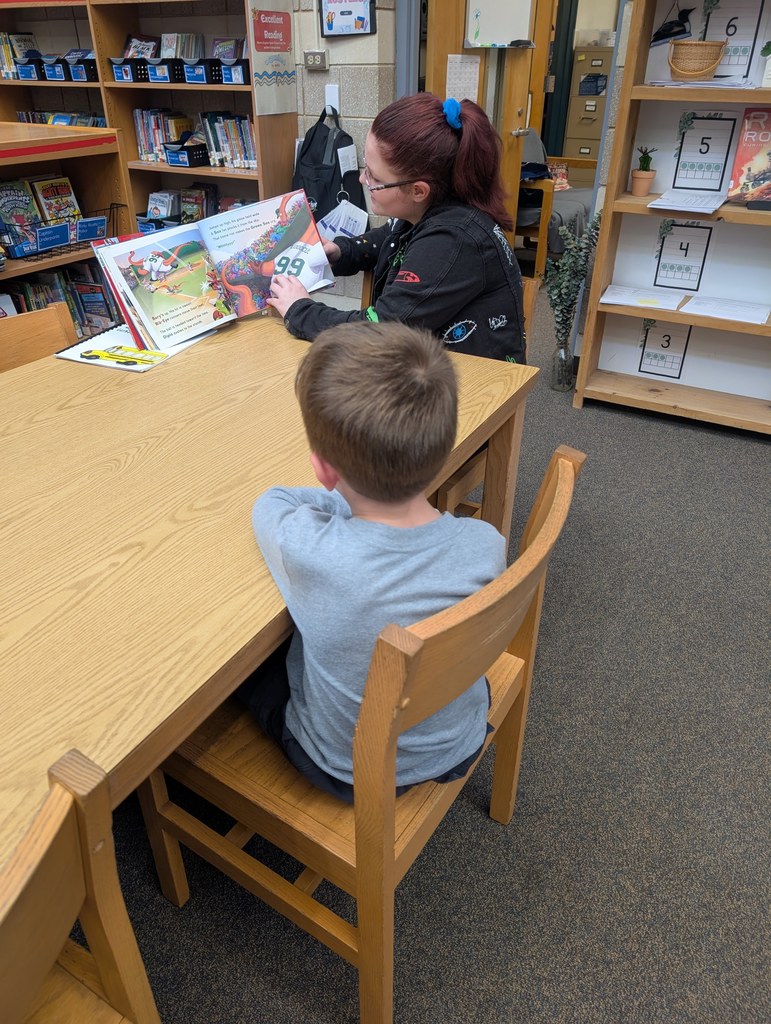 This picture is of a teacher reading to a student.