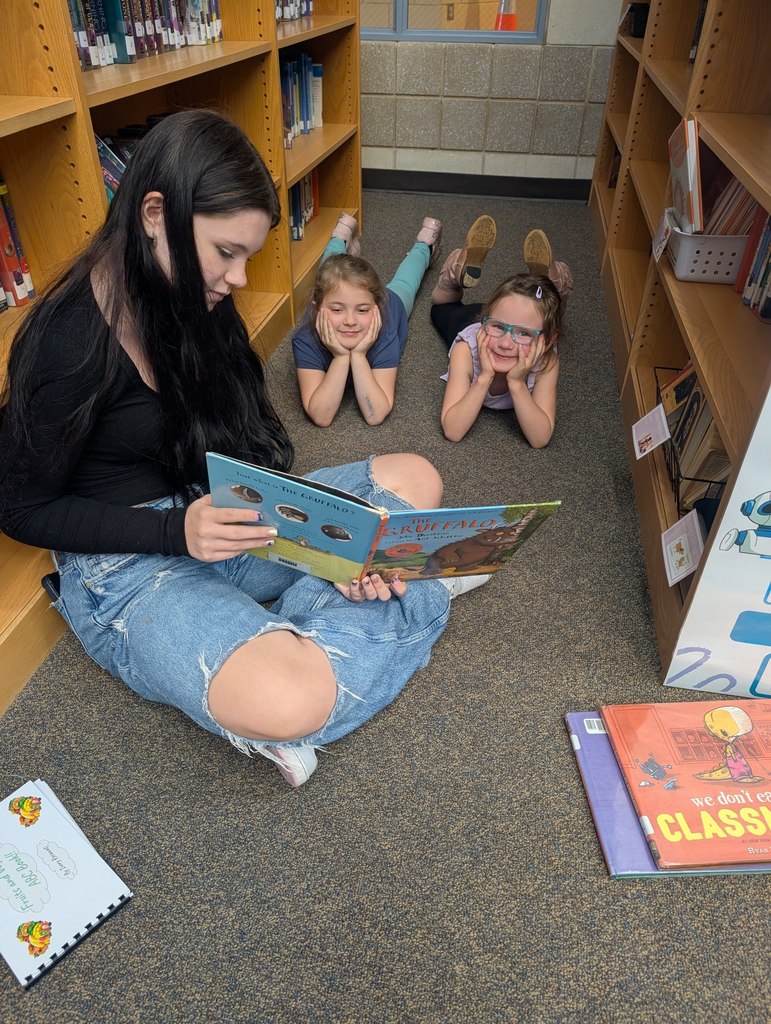 This picture is of a teacher reading to a student.