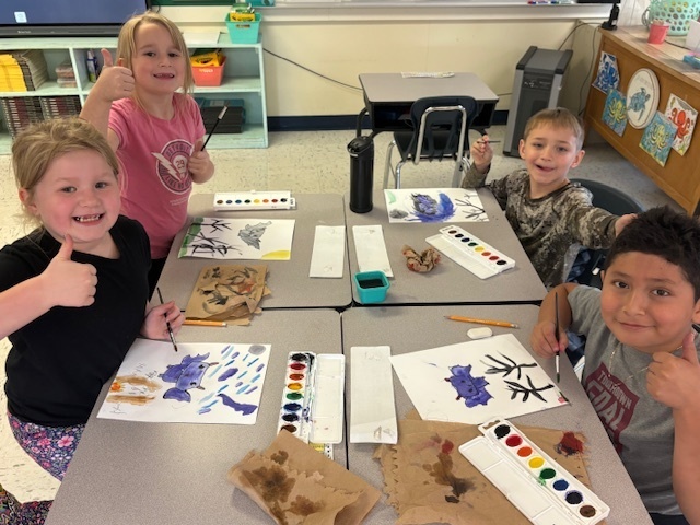 students showing their art.