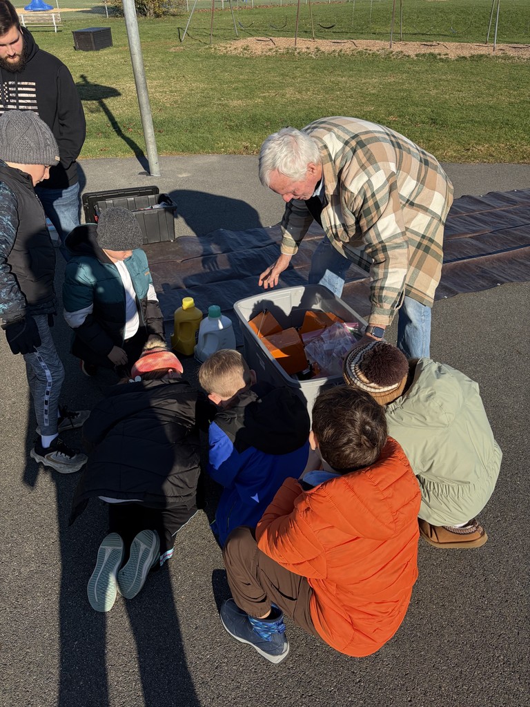 students watching as the balloon is getting prepared to take off.