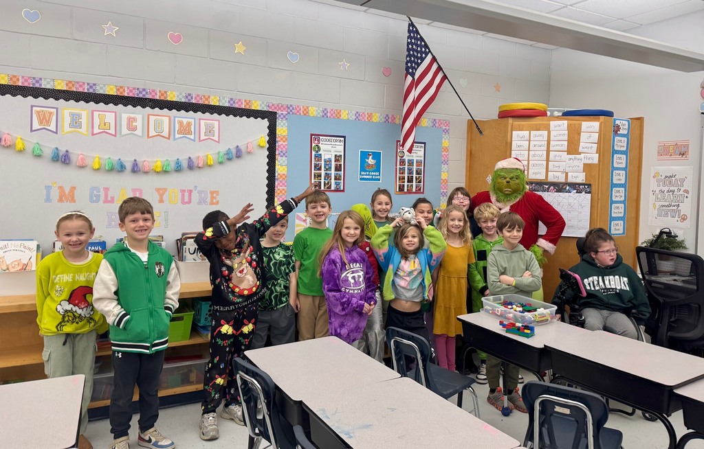 Students posing for a picture with the grinch.