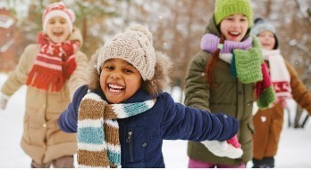 Picture of young people, in winter dress, outside enjoying the snow.